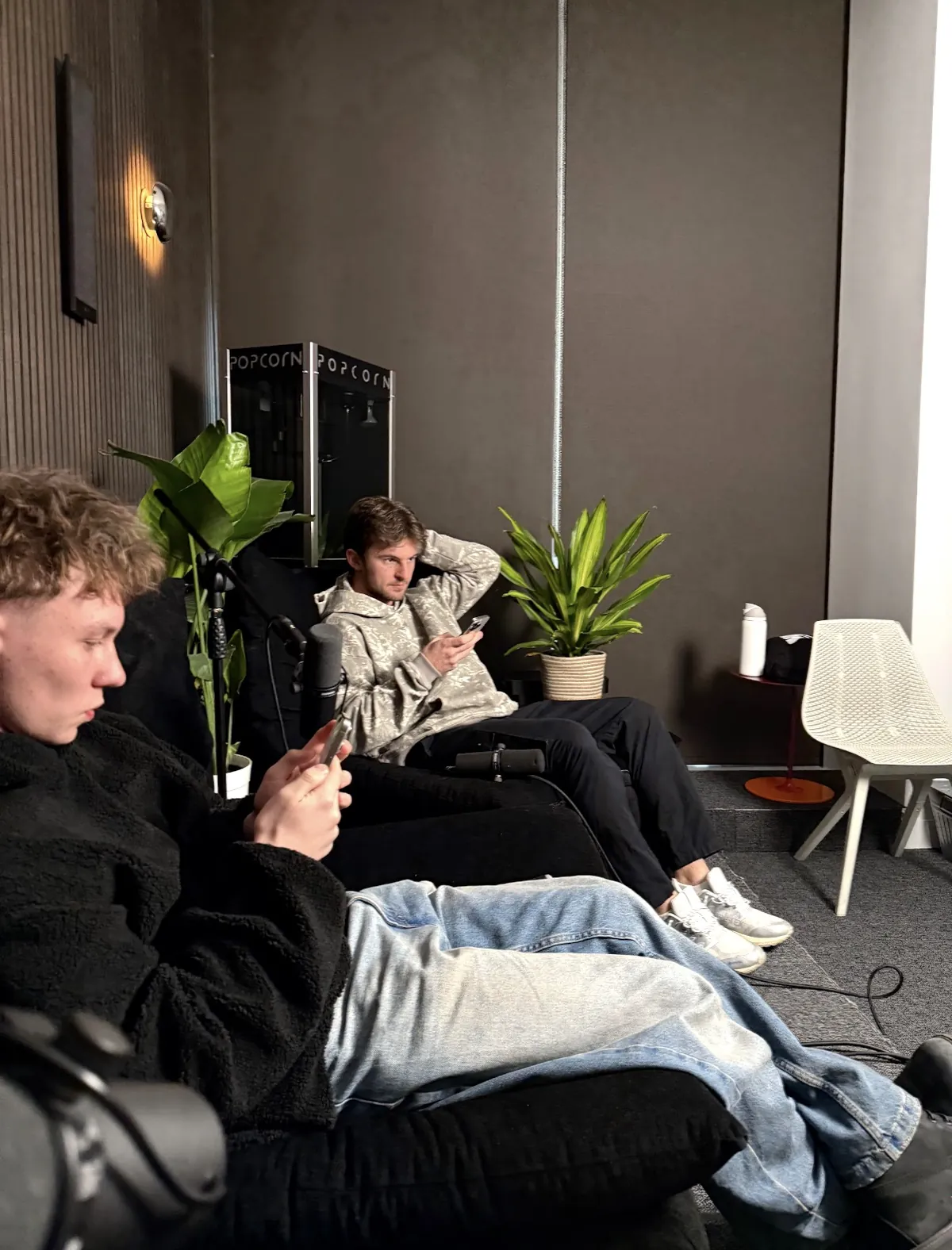 Two of the team in a studio with podcast mics