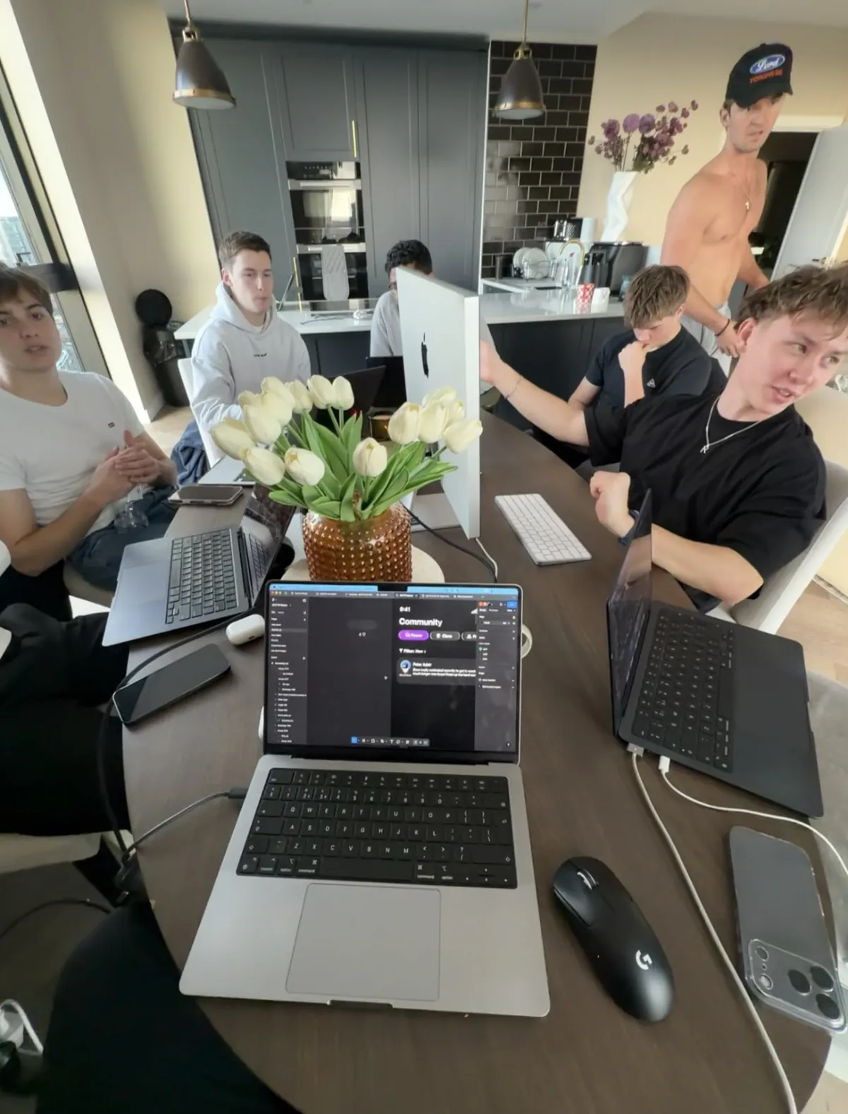 The team working round a kitchen table, the Community screen open on a laptop